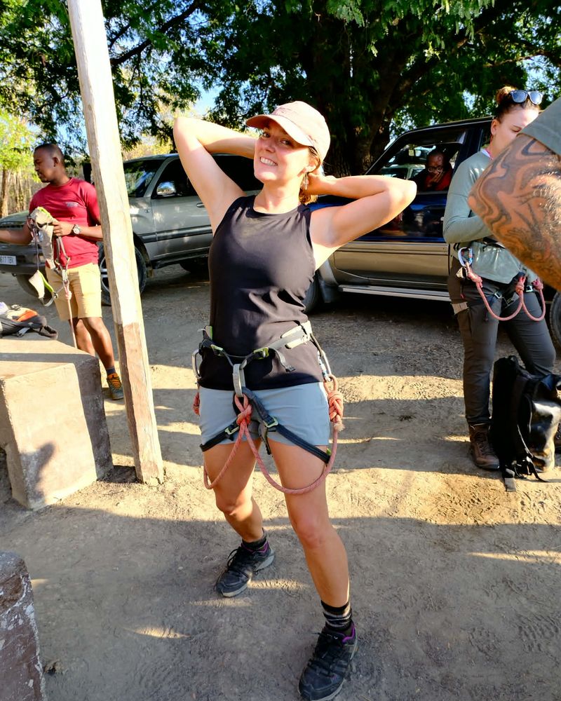 Amanda in a sun hat and hiking gear, striking a pose on a trip