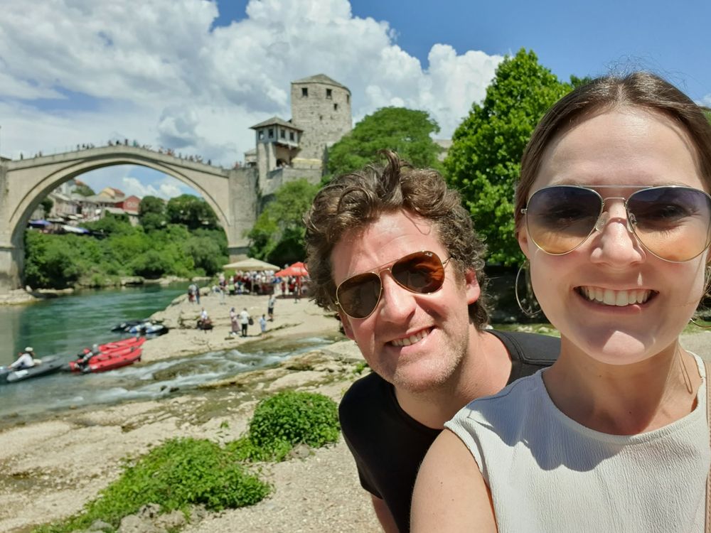 Two travellers in front of the old bridge at Mostar, Bosnia