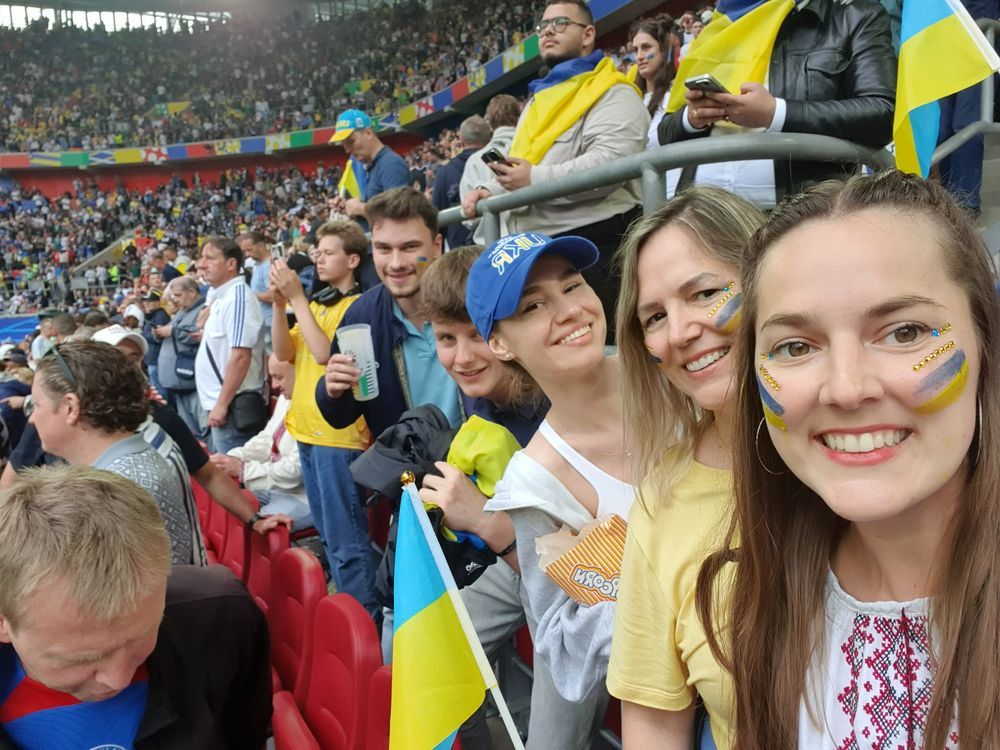 Travellers with painted faces and flags in a packed football stadium
