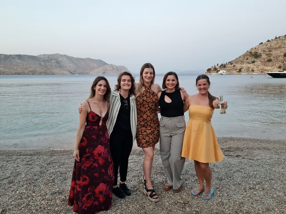 Five travellers dressed up on a Greek beach at dusk