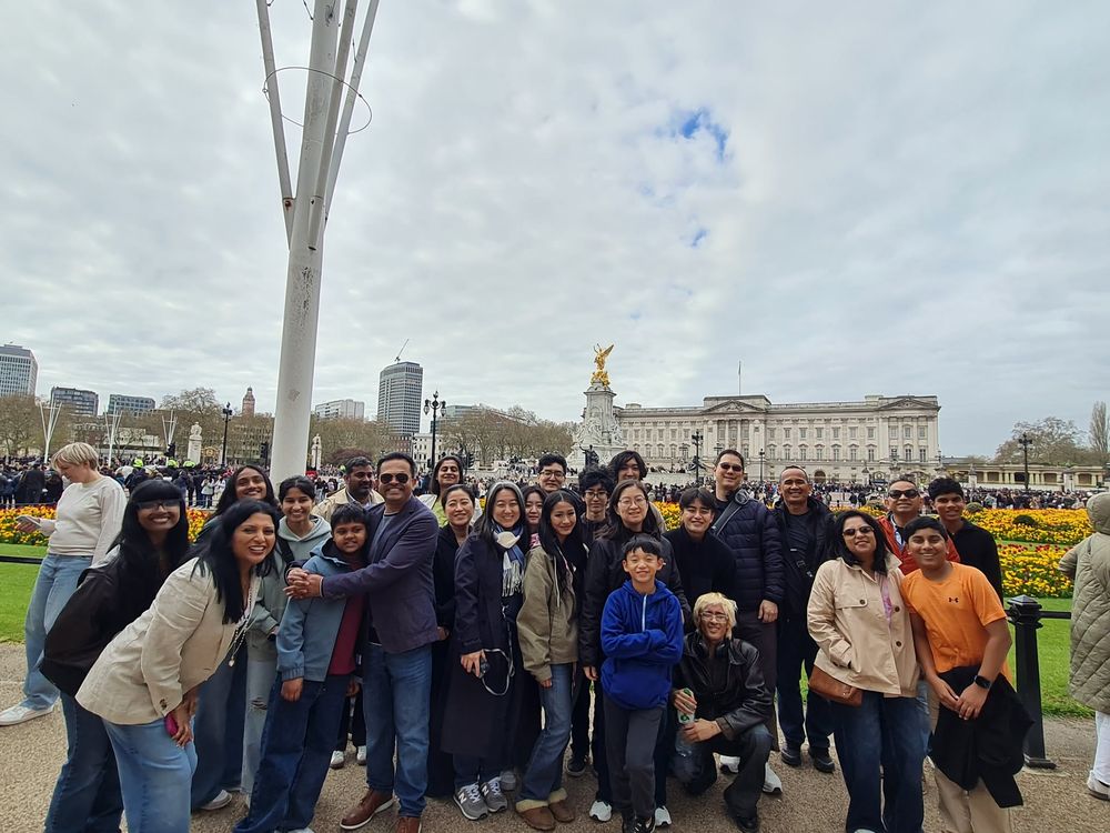 A large group photo in front of Buckingham Palace in London